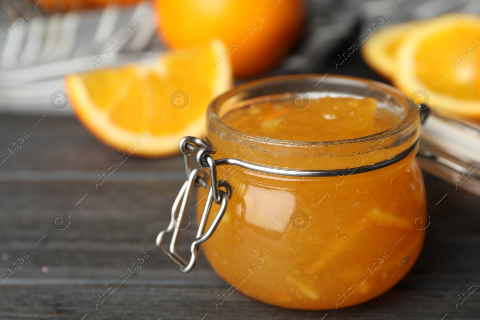 Photo of Jar of orange jam on grey wooden table