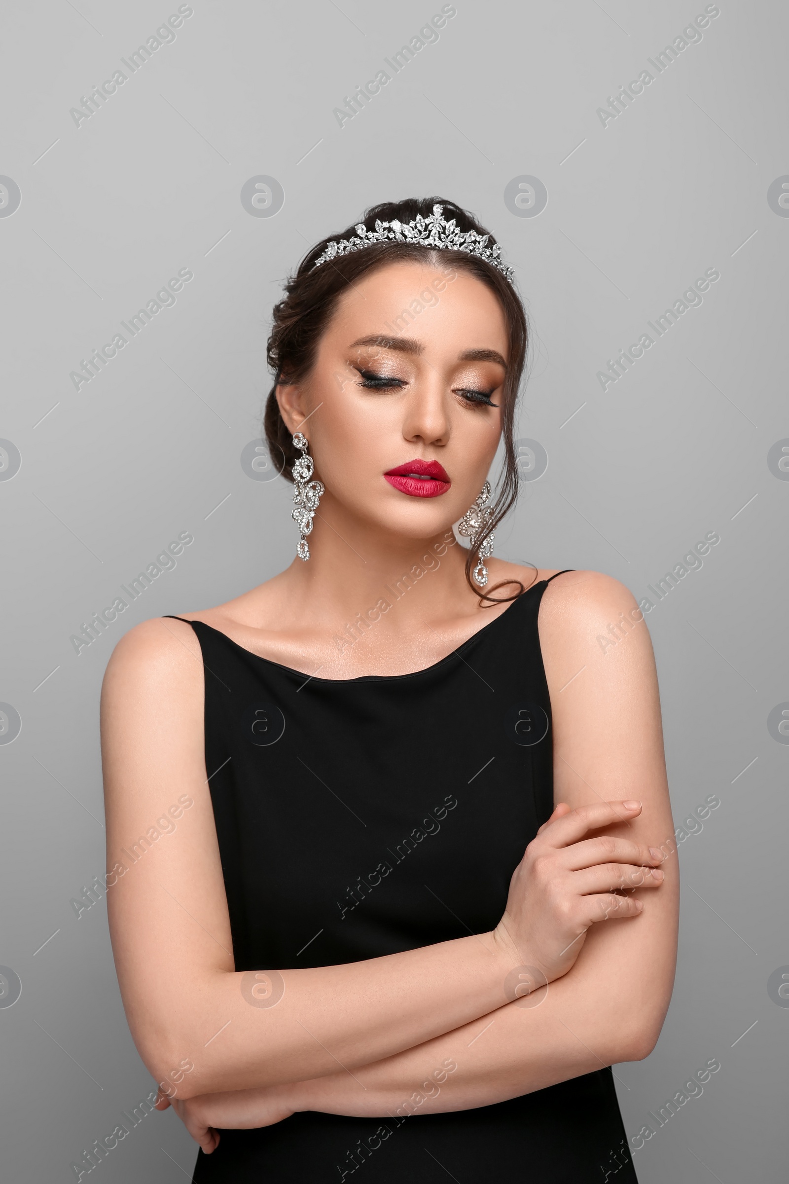 Photo of Beautiful young woman wearing luxurious tiara on light grey background