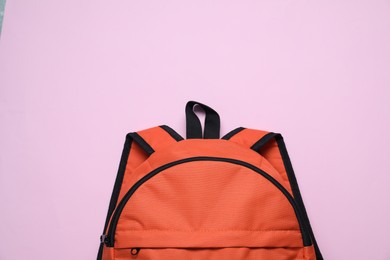 Photo of Stylish orange backpack on violet background, top view