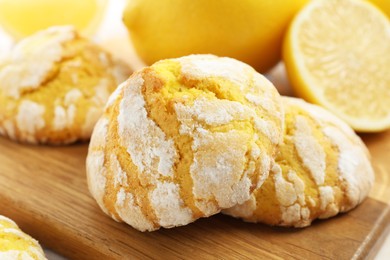 Photo of Tasty homemade lemon cookies on wooden board, closeup