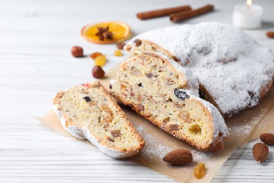 Traditional Christmas Stollen with icing sugar on white wooden table