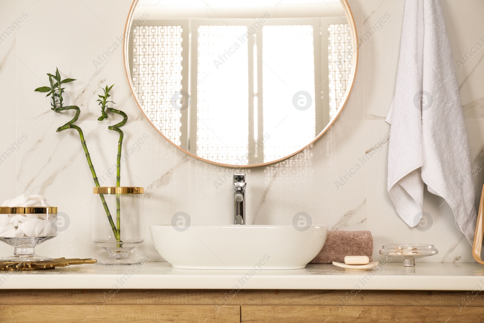 Photo of Stylish bathroom interior with vessel sink and round mirror