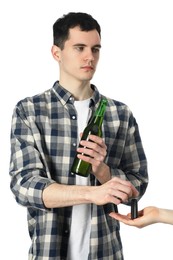 Photo of Man with bottle of beer giving car key to woman on white background, closeup. Don't drink and drive concept