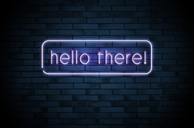 Image of Stylish neon sign with phrase Hello there on brick wall