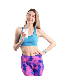 Beautiful young woman in sportswear drinking milk on white background