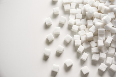 Photo of Refined sugar cubes on light background