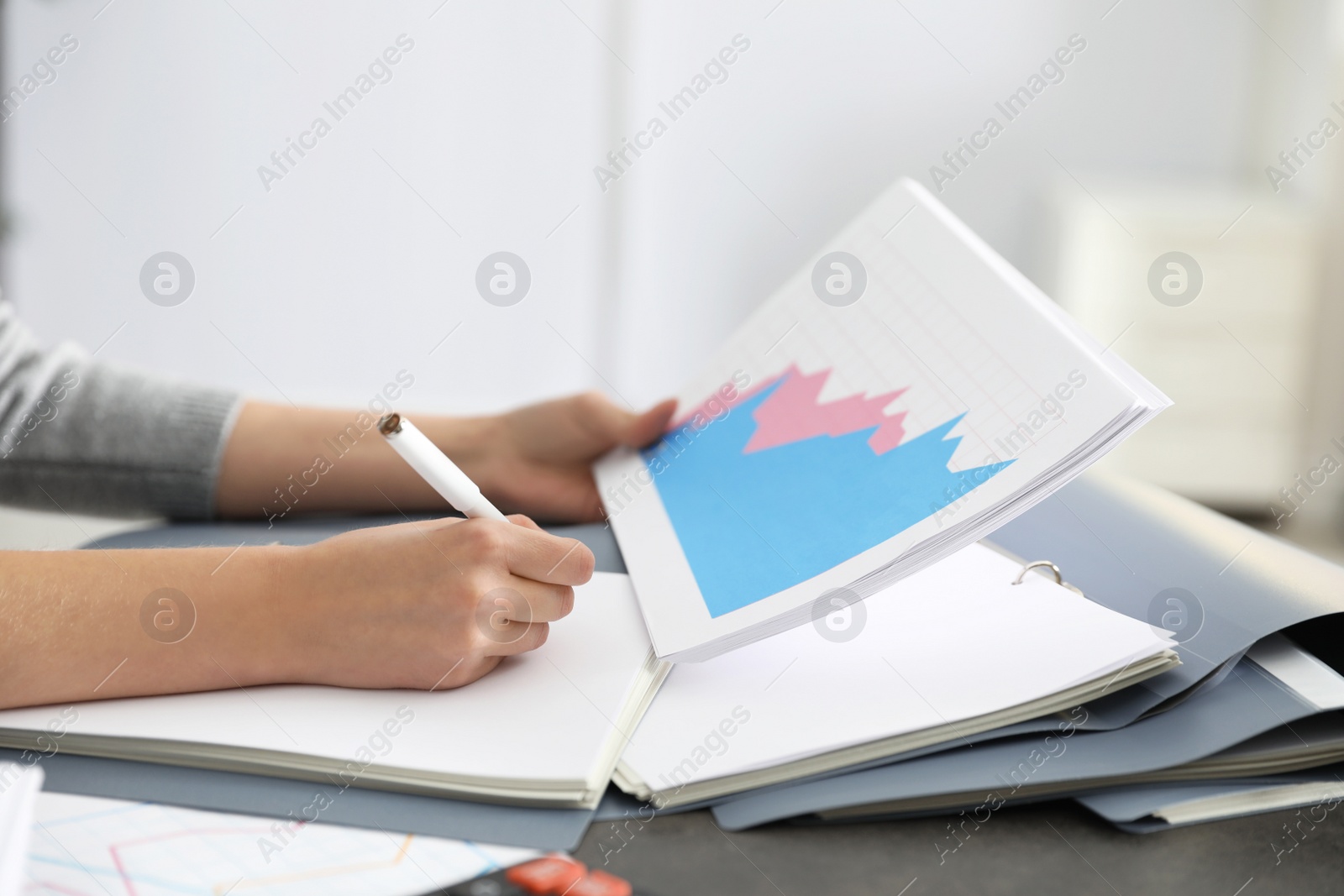 Photo of Office employee working with documents at table, closeup