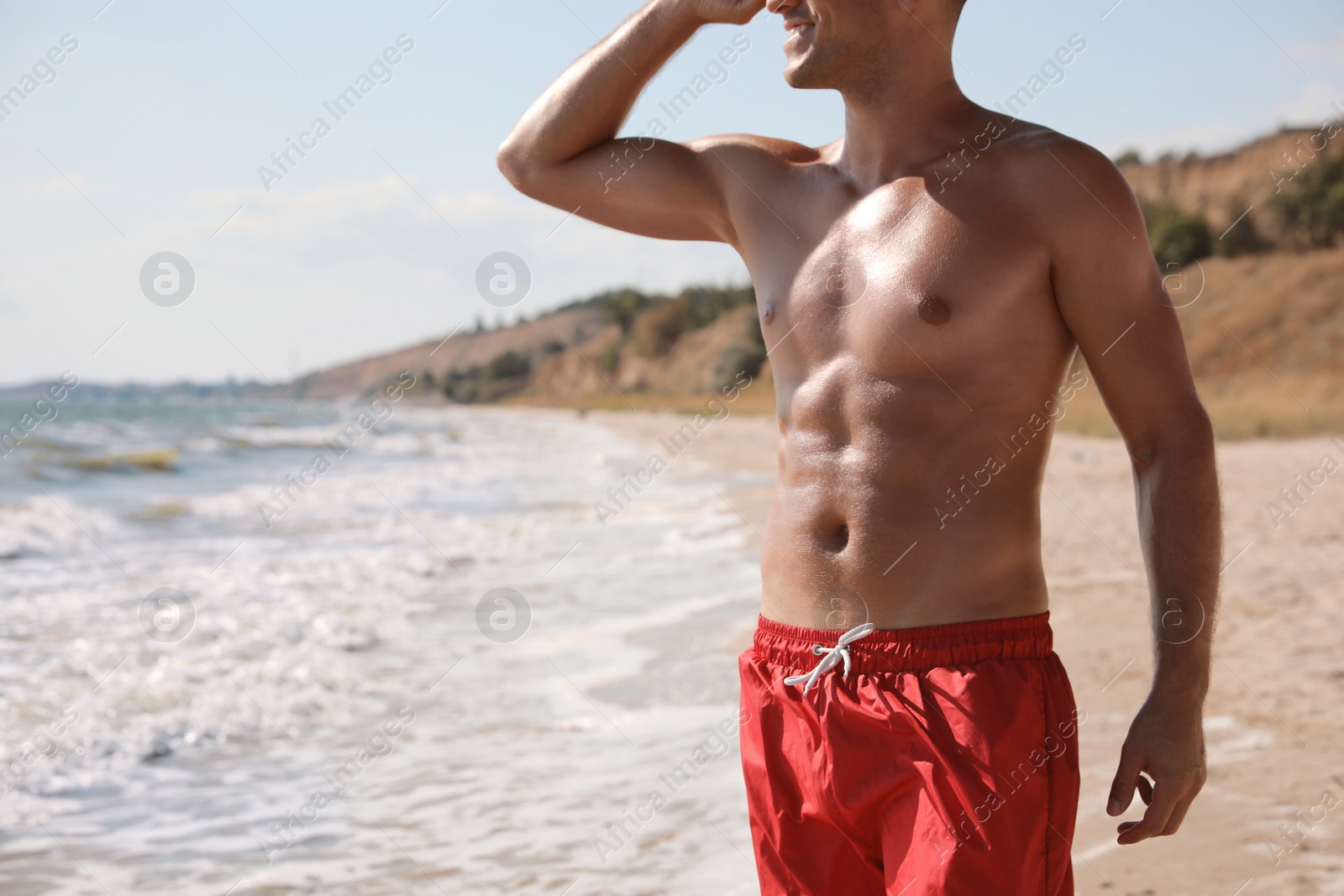 Photo of Man with attractive body on beach, closeup