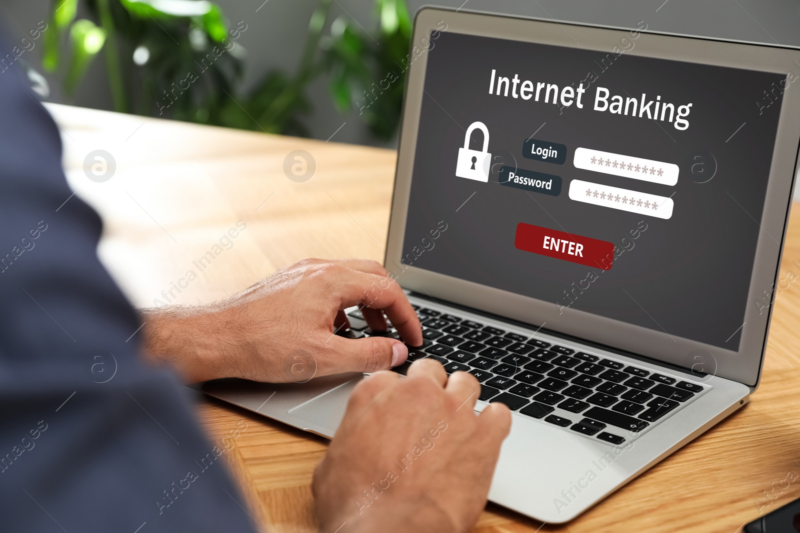 Image of Man using online banking application on laptop at wooden table, closeup