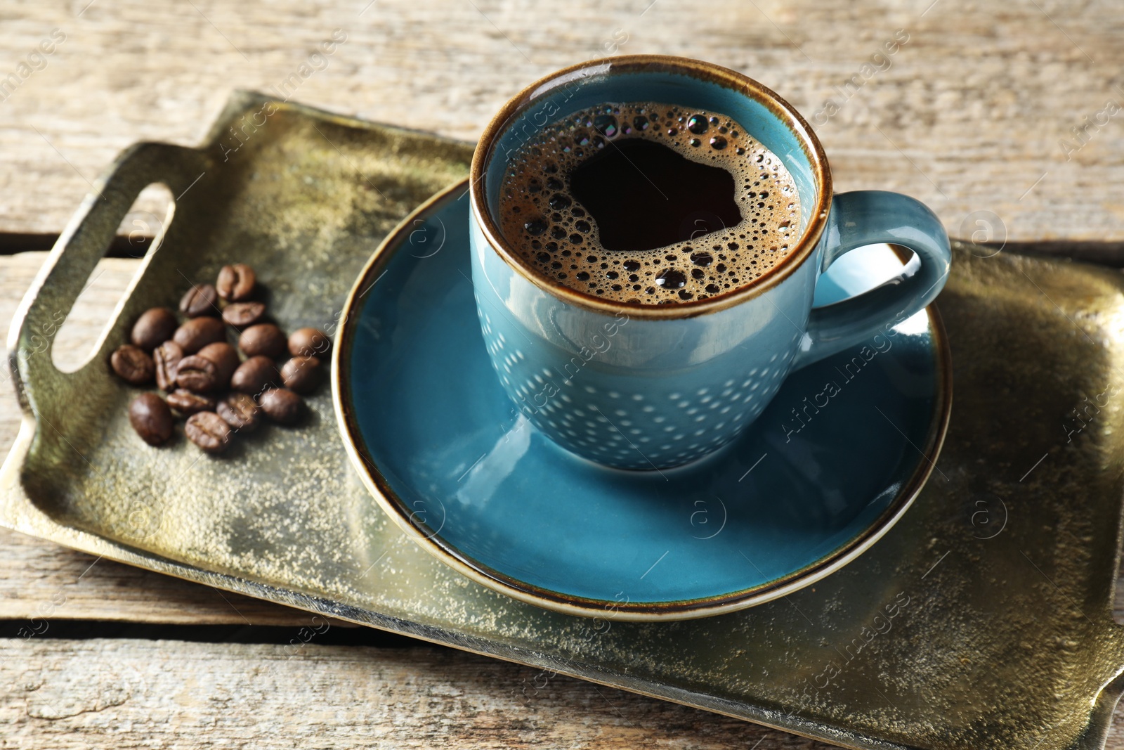 Photo of Turkish coffee. Freshly brewed beverage and beans on wooden table, closeup