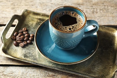 Photo of Turkish coffee. Freshly brewed beverage and beans on wooden table, closeup