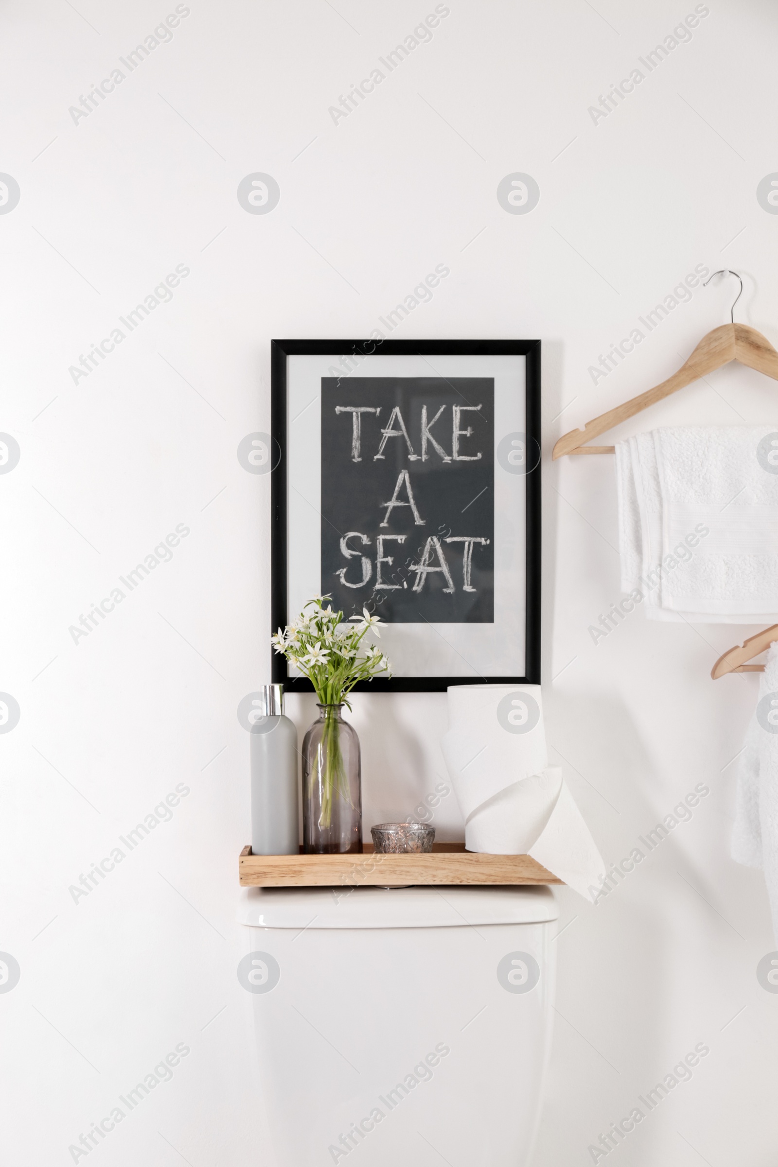 Photo of Decor elements, necessities and toilet bowl near white wall. Bathroom interior