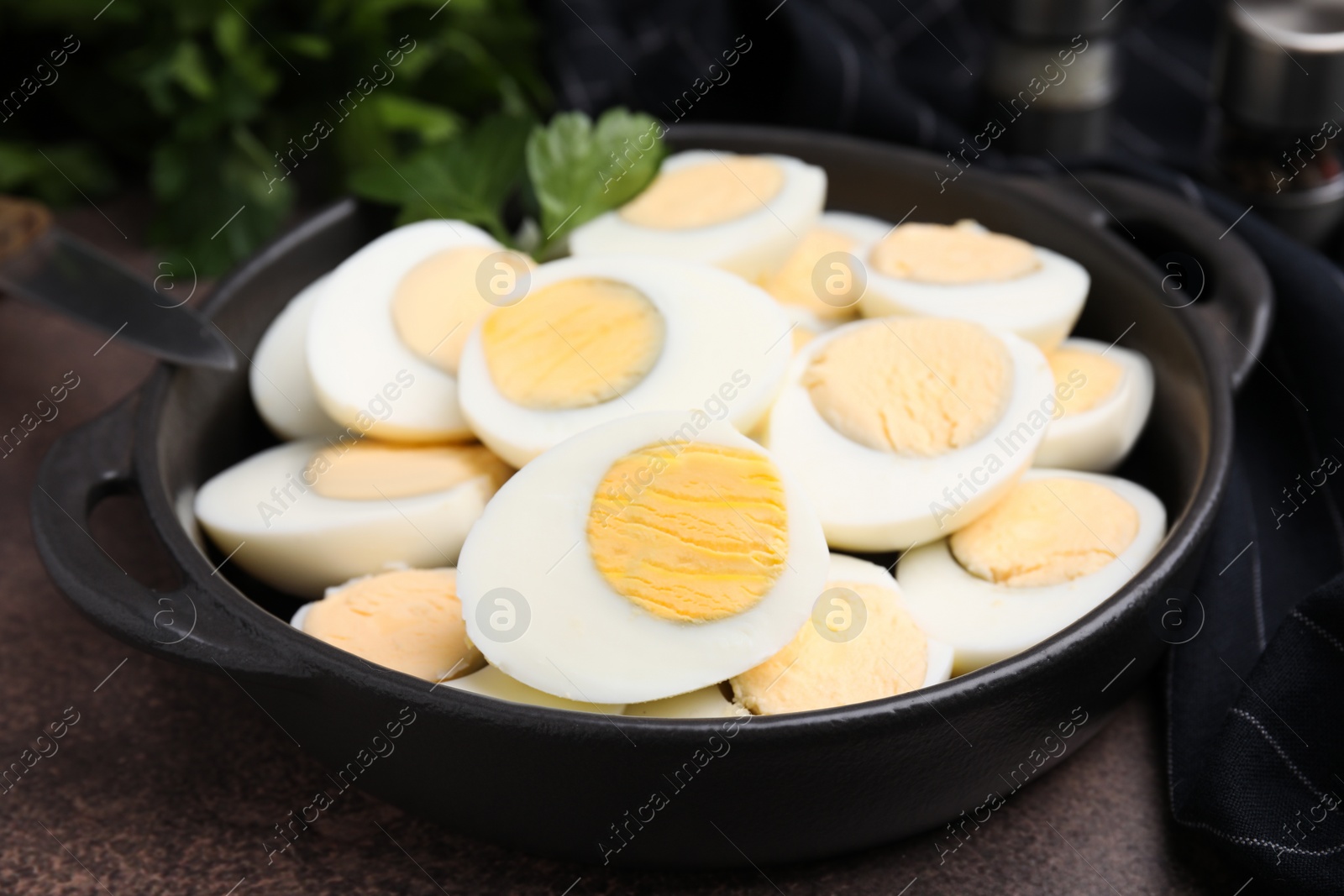 Photo of Fresh hard boiled eggs and parsley on brown table, closeup