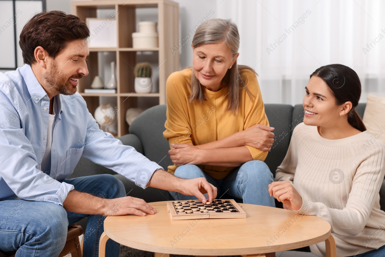 Photo of Family playing checkers at coffee table in room