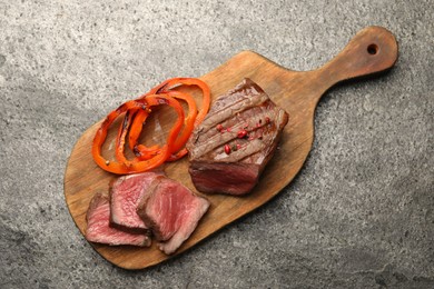 Photo of Delicious grilled beef steak with spices on gray table, top view