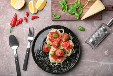 Photo of Delicious pasta with meatballs and tomato sauce on grey background, flat lay