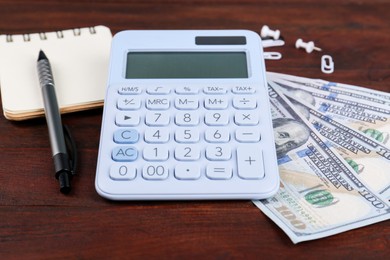 Calculator, notebook, pen and dollar banknotes on wooden table. Retirement concept