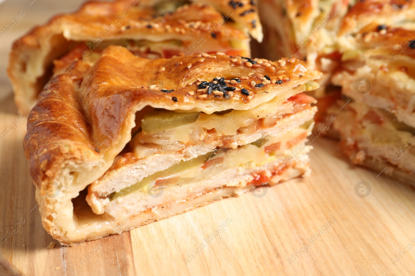 Photo of Cut delicious homemade pie on wooden table, closeup