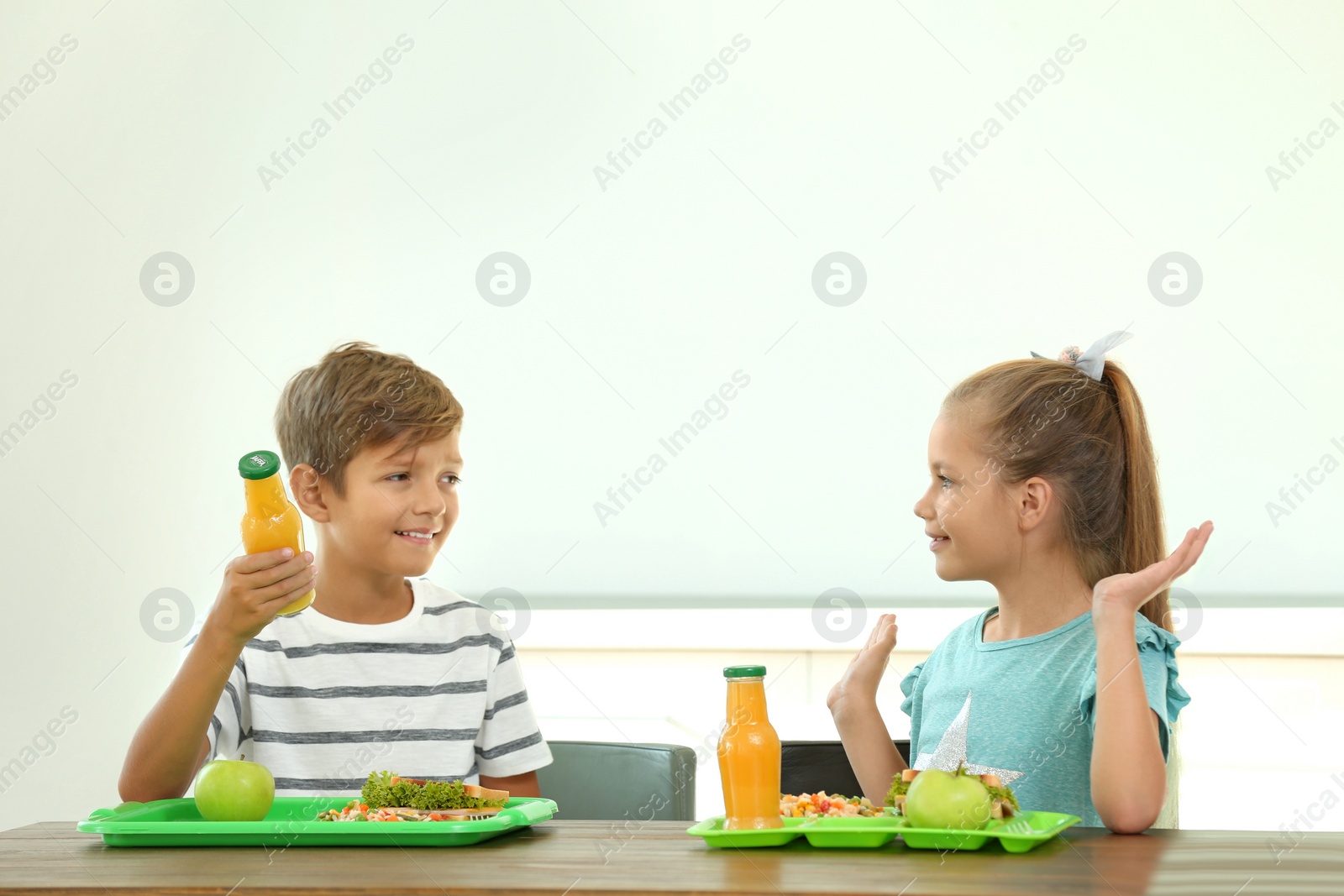 Photo of Happy children eating healthy food for lunch in school canteen