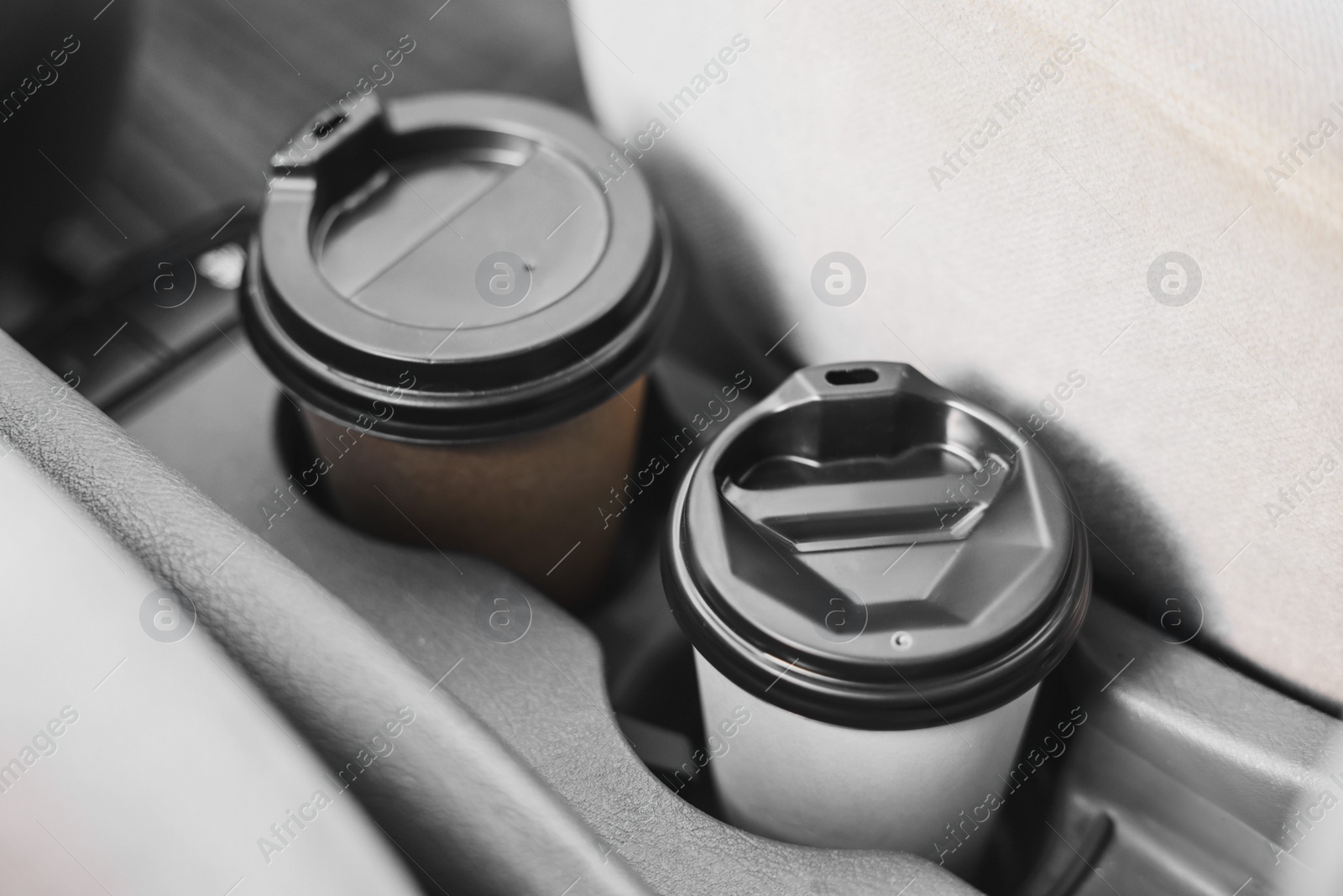 Photo of Coffee to go. Paper cups with tasty drink in holder inside of car, closeup