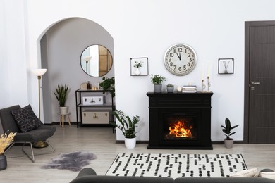 Photo of Stylish living room interior with fireplace and green plants