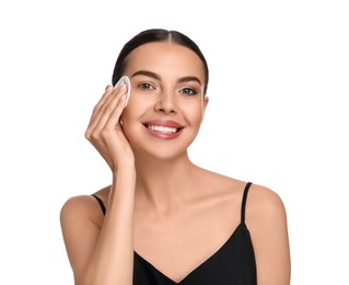 Beautiful woman removing makeup with cotton pad on white background