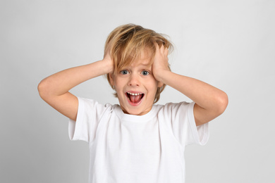 Photo of Emotional little boy on light grey background