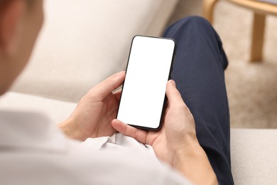 Photo of Man using smartphone with blank screen indoors, closeup. Mockup for design