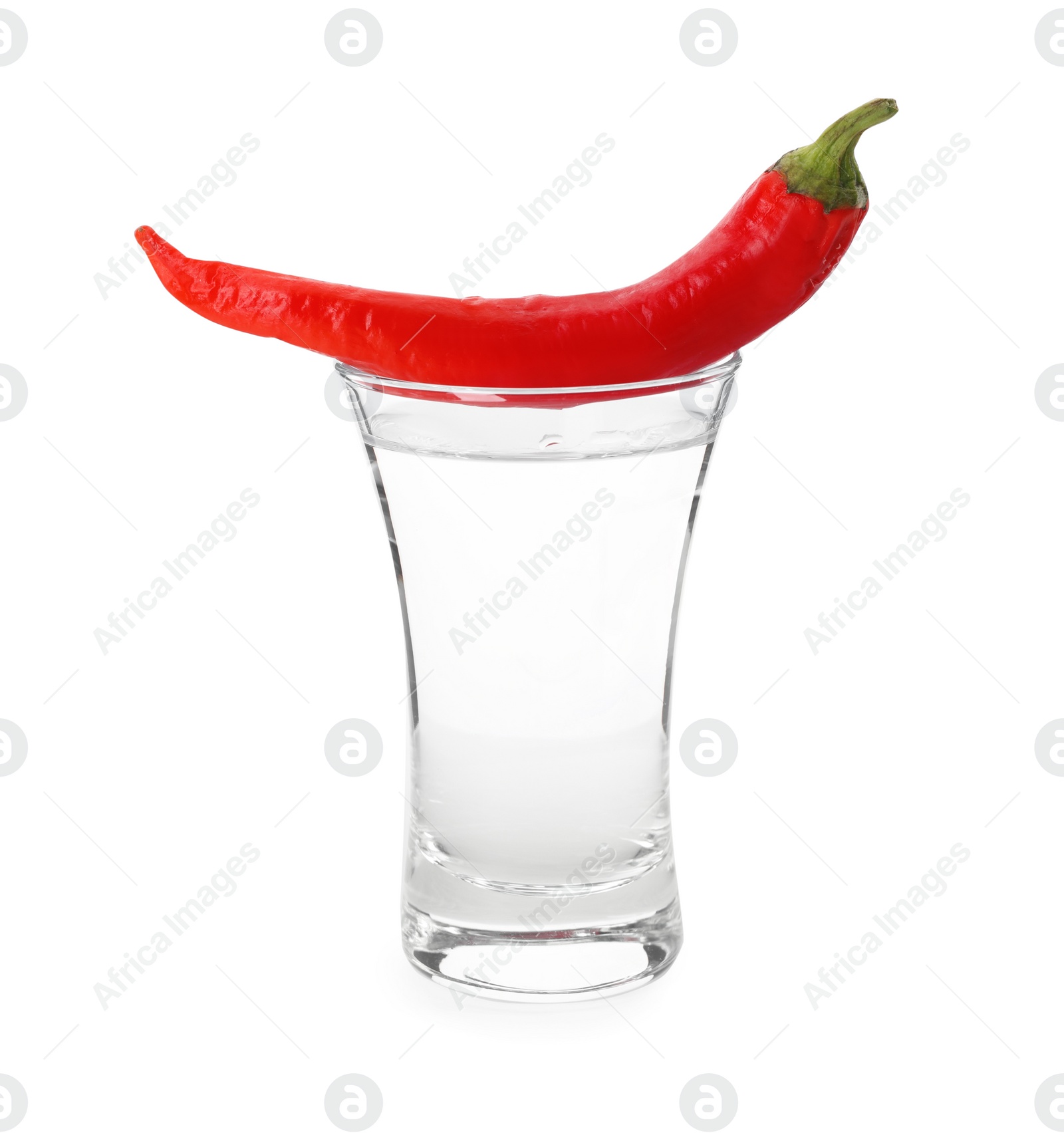 Photo of Red hot chili pepper and vodka in shot glass on white background