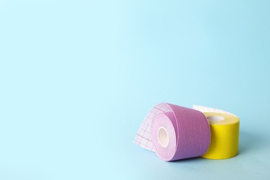 Bright kinesio tape in rolls on light blue background. Space for text