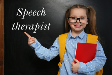 Cute little child near chalkboard and text Speech Therapist 