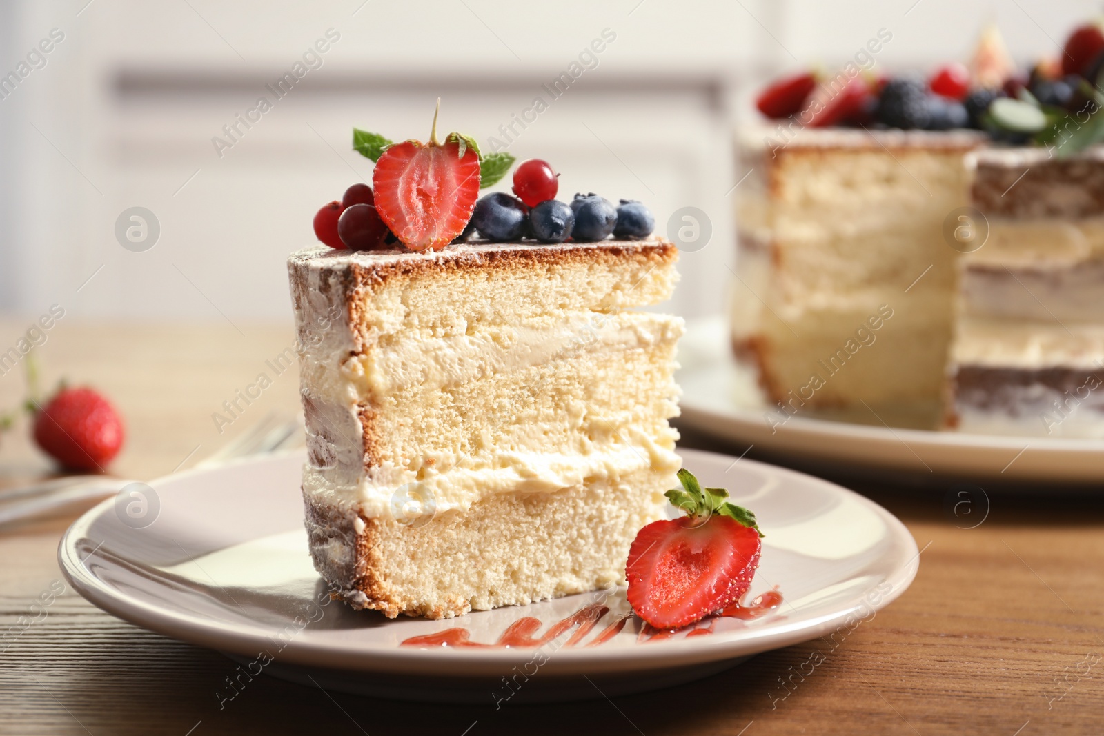 Photo of Piece of delicious homemade cake with fresh berries served on wooden table