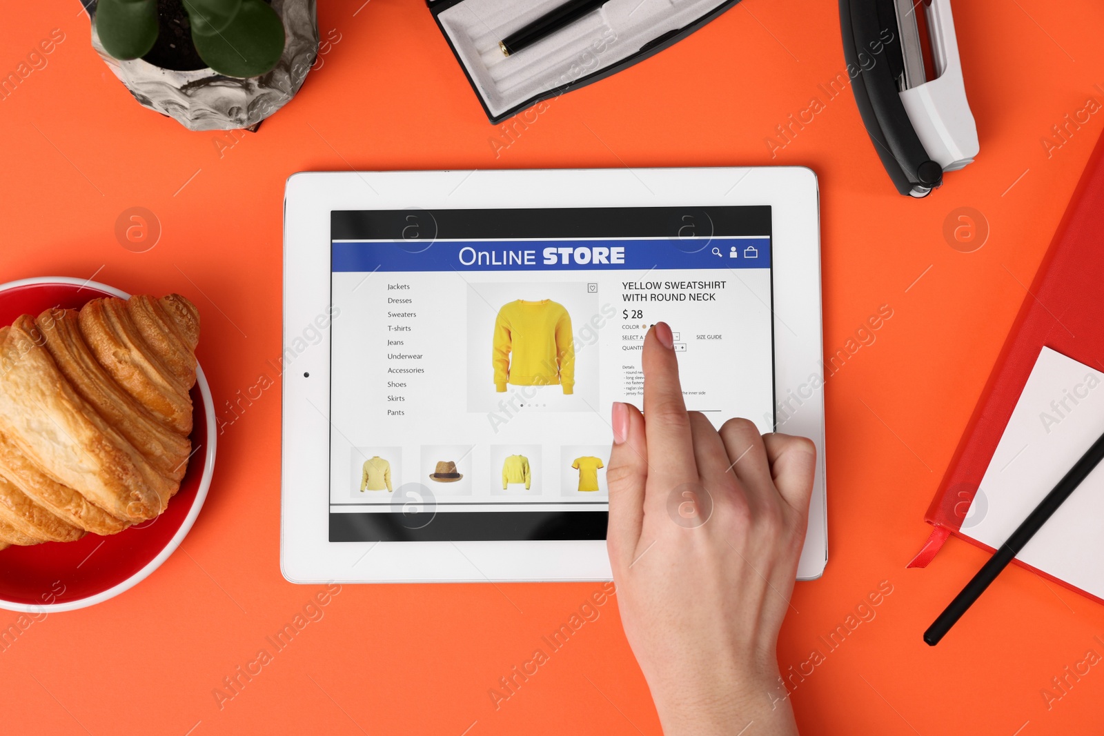 Photo of Woman with tablet shopping online on orange background, top view