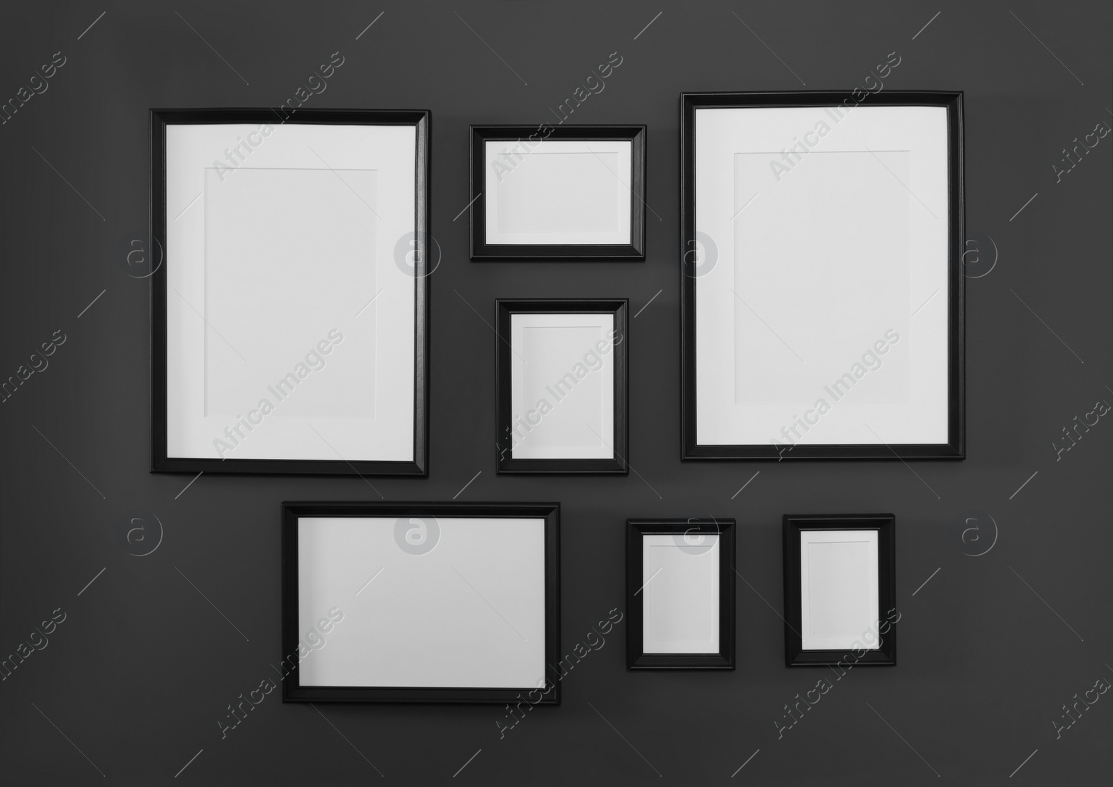 Photo of Empty frames on black wall. Mockup for design