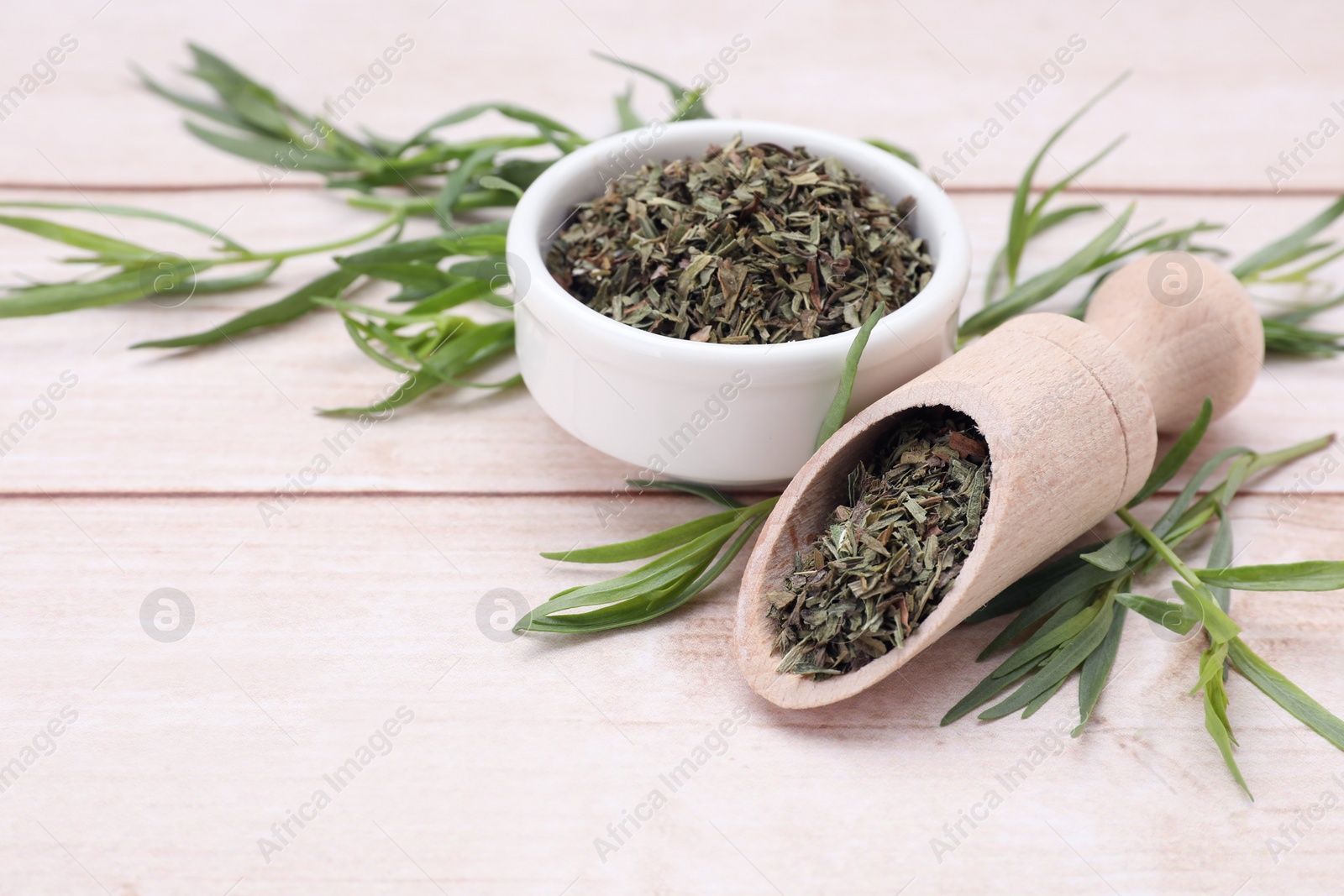Photo of Dry and fresh tarragon on wooden table, space for text