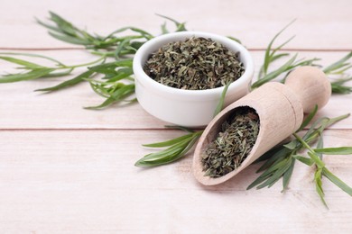 Dry and fresh tarragon on wooden table, space for text