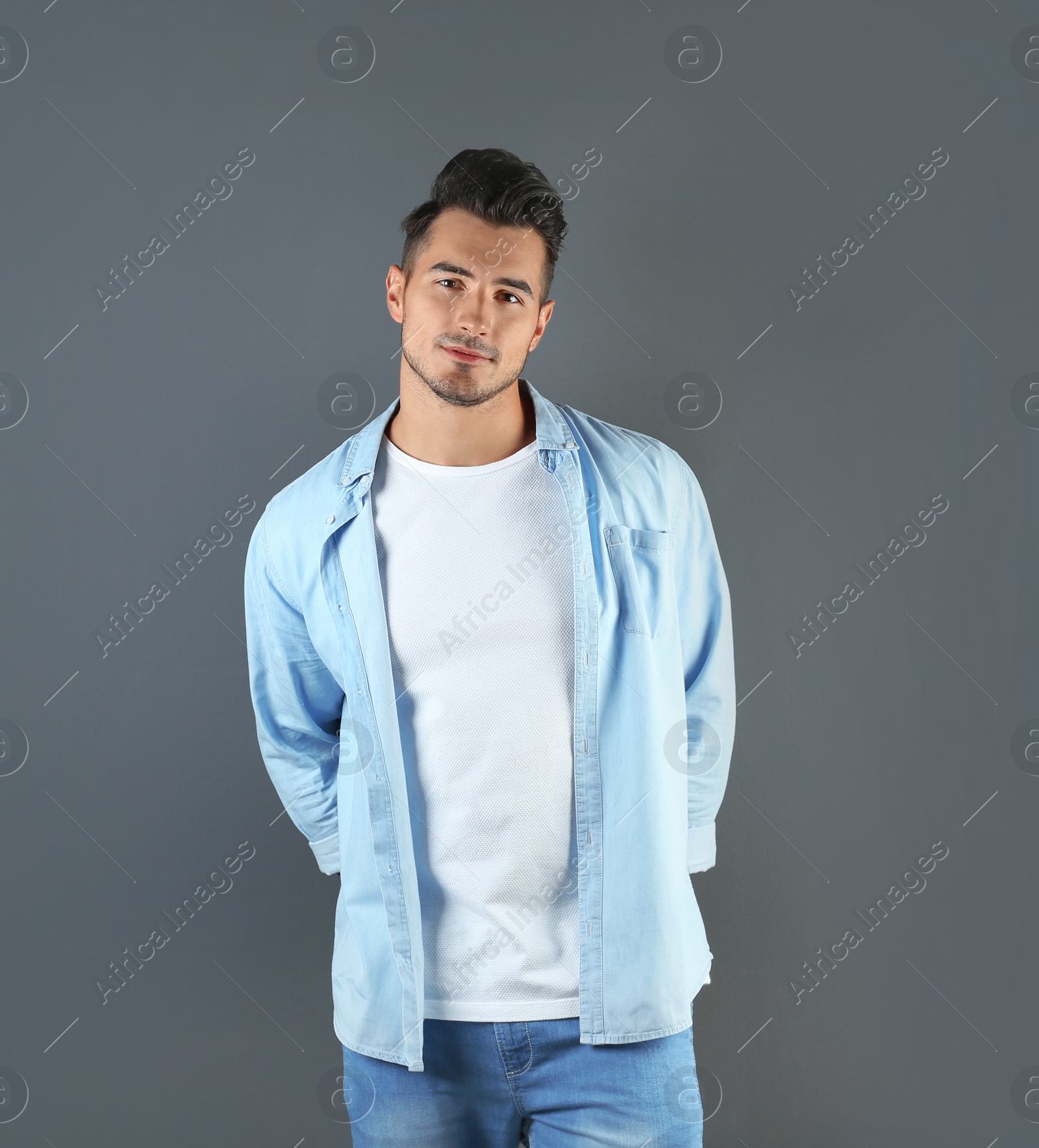 Photo of Young man in t-shirt on grey background. Mockup for design