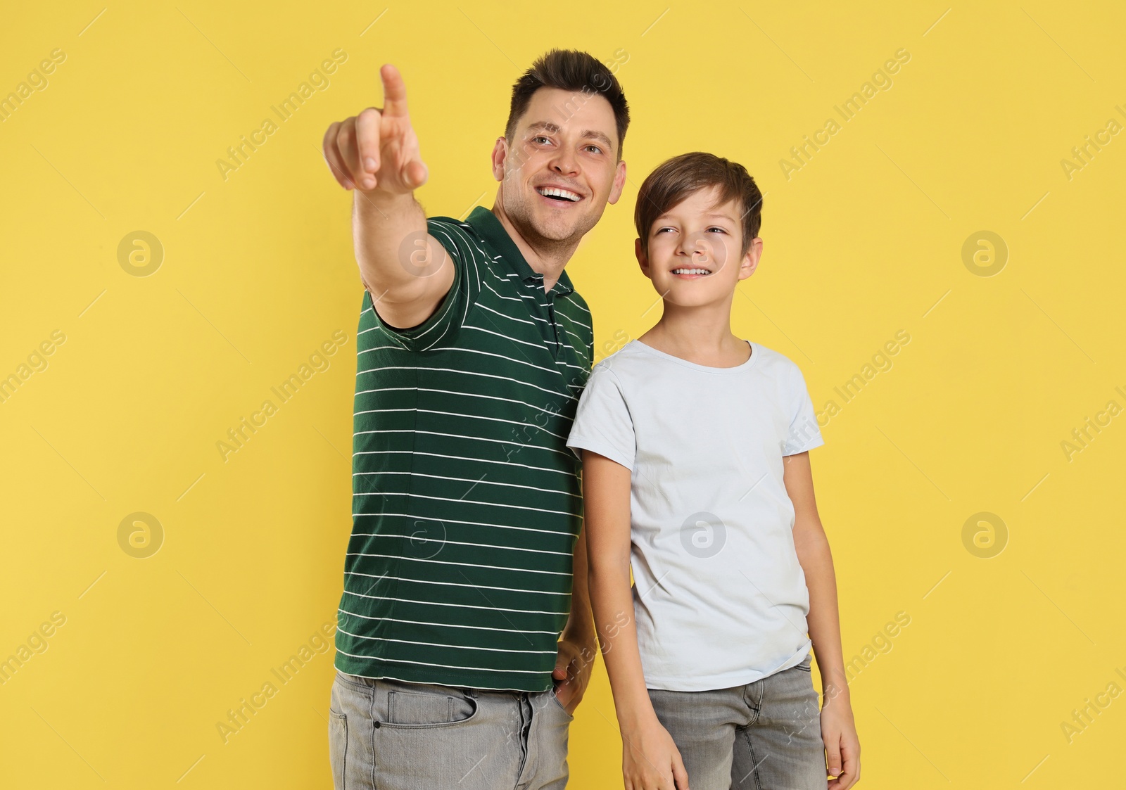 Photo of Portrait of dad and his son on color background