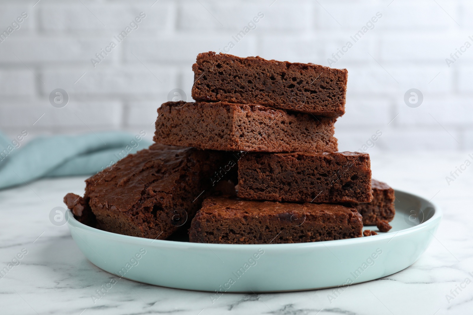 Photo of Delicious chocolate brownies on white marble table