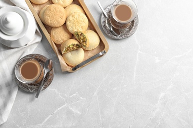 Flat lay composition with tray of cookies for Islamic holidays, cups and space for text on table. Eid Mubarak