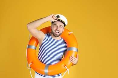 Happy sailor with ring buoy on yellow background
