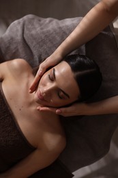 Spa therapy. Beautiful young woman lying on table during massage in salon, above view