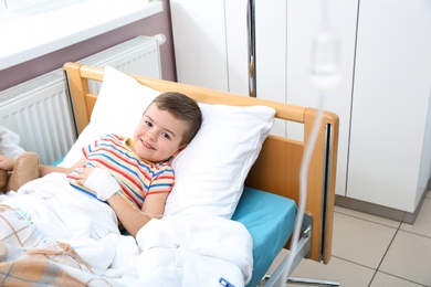 Little child with intravenous drip in hospital bed