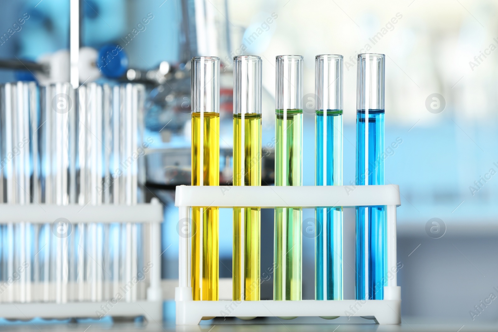 Photo of Test tubes with colorful liquids on table in laboratory