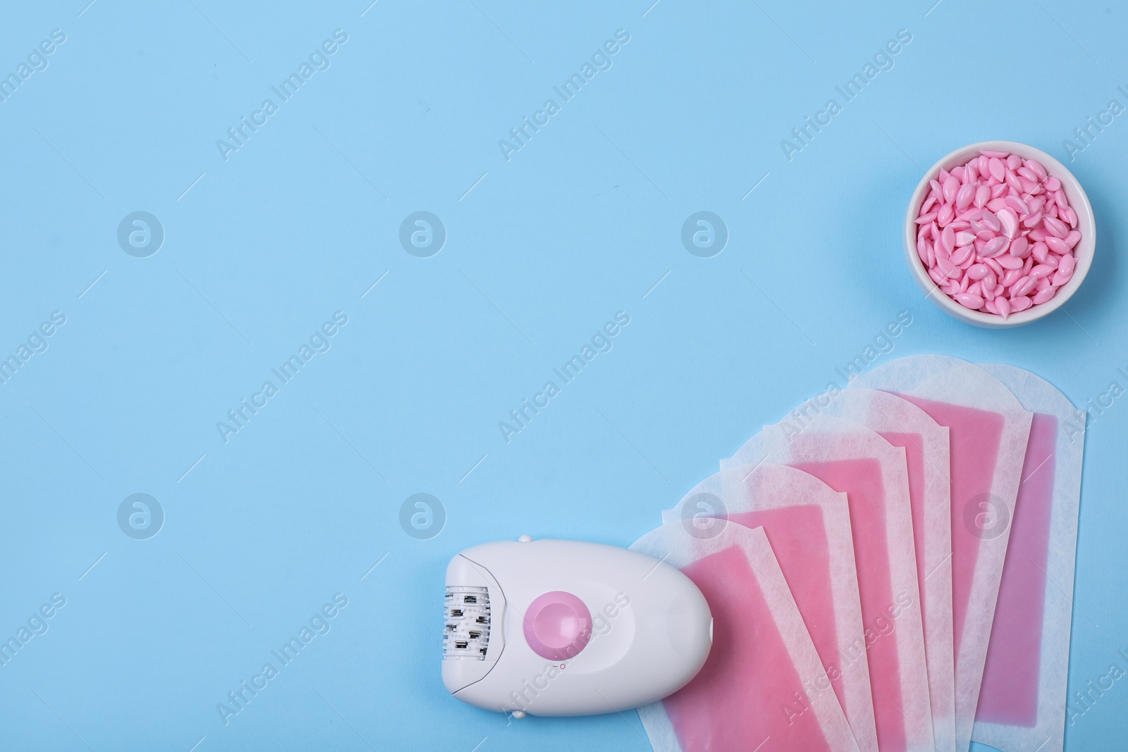 Photo of Set of epilation products on light blue background, flat lay. Space for text