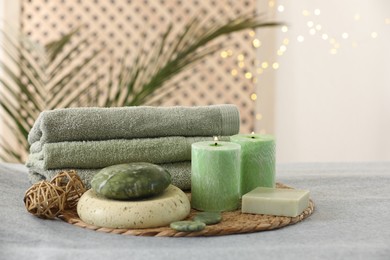 Spa composition. Burning candles, stones, soap and towels on soft grey surface