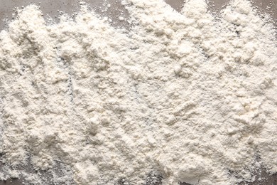 Photo of Scattered flour on grey table, top view