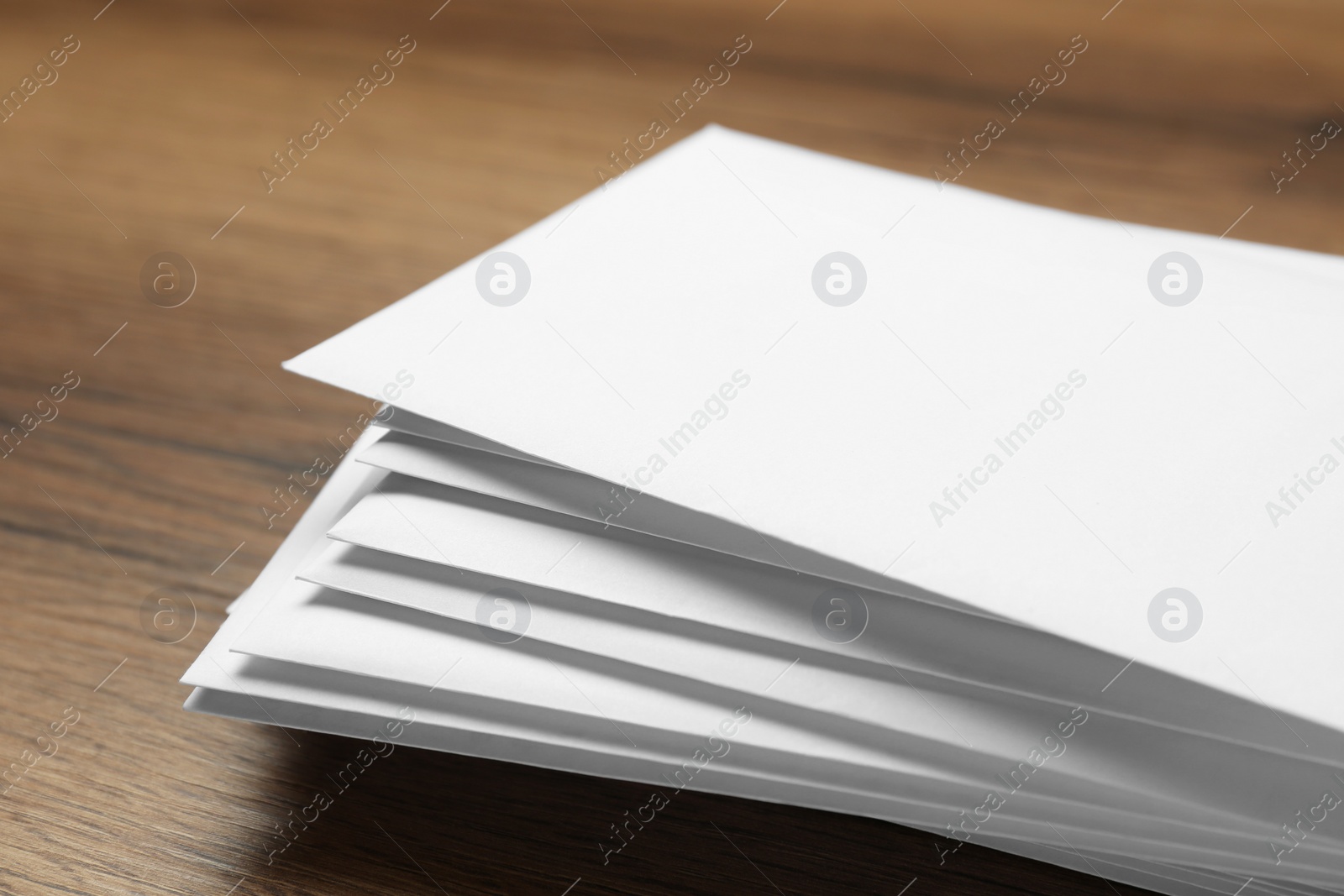 Photo of Stack of letters on wooden table, closeup