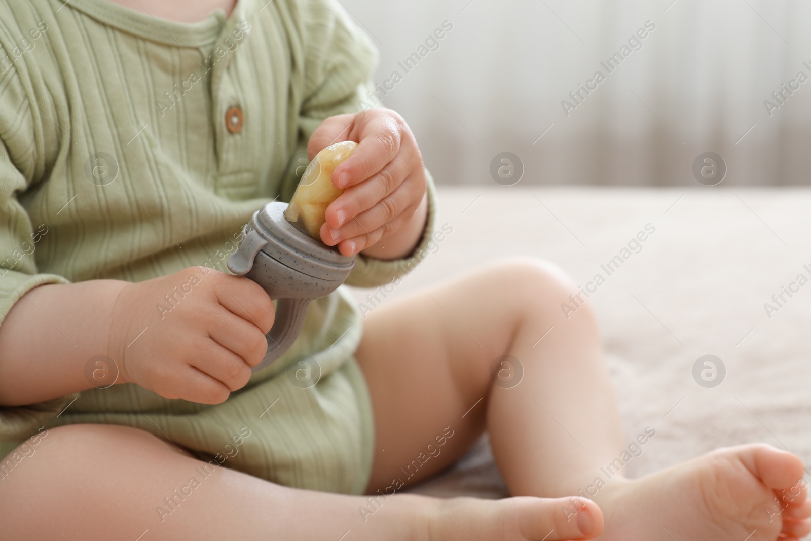 Photo of Baby with nibbler at home, closeup view