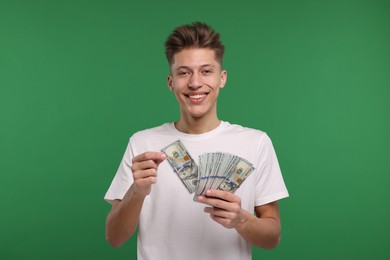 Photo of Happy man with dollar banknotes on green background